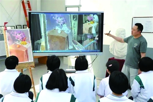 美术老师褚国梁在指导学生作画